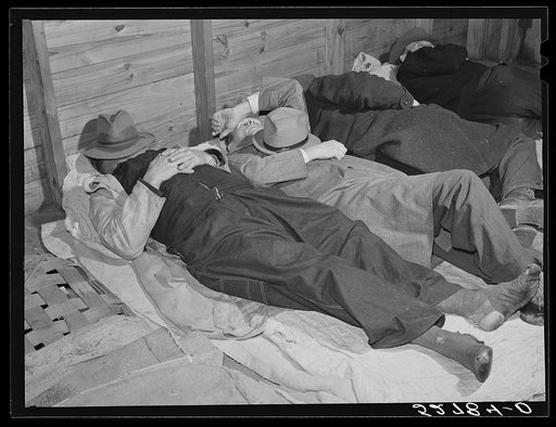 Farmers sleeping in white camp room in warehouse. They often must remain overnight or several days before their tobacco is auctioned. Durham, North Carolina