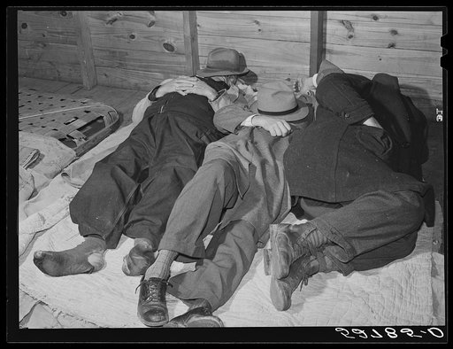 Farmers sleeping in white camp room in warehouse. They often must remain overnight or several days before their tobacco is auctioned. Durham, North Carolina