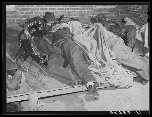 Farmers sleeping in white camp room in warehouse. They often must remain overnight or several days before their tobacco is auctioned. Durham, North Carolina
