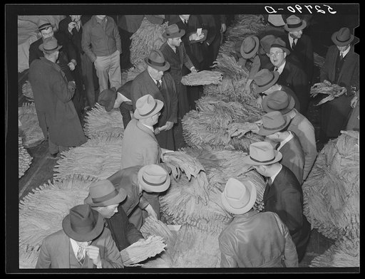 Auctioneer, buyers, and farmers during tobacco auction sale. Warehouse, Durham, North Carolina