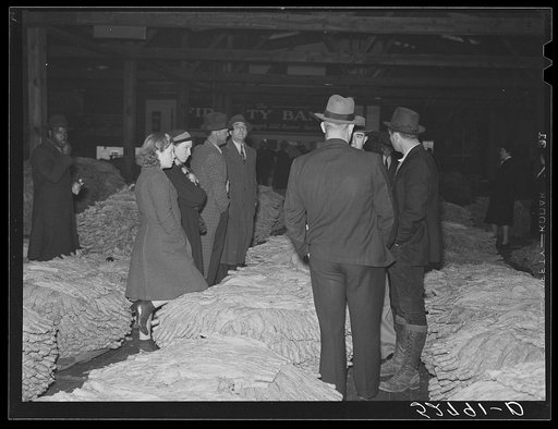 Untitled photo, possibly related to: Auctioneer, buyers, and farmers during tobacco auction sale. Warehouse, Durham, North Carolina