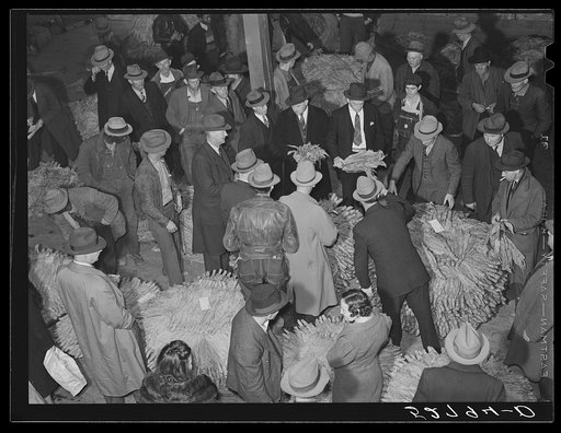 Auctioneer, buyers, and farmers during tobacco auction sale. Warehouse, Durham, North Carolina