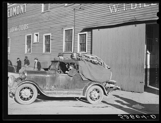 Farmer taking his tobacco from one warehouse to another for auction sale.  Most of the warehouses are very rushed and quickly filled up the first of the week because most farmers think they get a better price on Monday and Tuesday. Mebane, Orange County, North Carolina