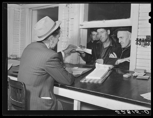 Farmers getting their checks in warehouse office after their tobacco has been sold at auction. Durham, North Carolina