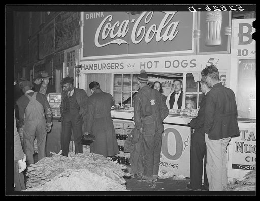 Untitled photo, possibly related to: Farmers listening to shoe salesman in warehouse during tobacco auctions. Durham, North Carolina