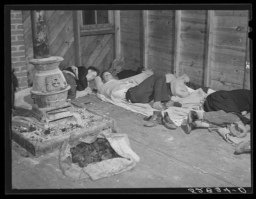 Farmers sleeping in white camp room in warehouse. They often must remain overnight or several days before their tobacco is auctioned. Durham, North Carolina