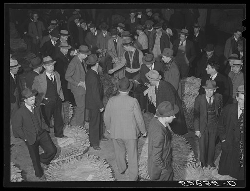 Auctioneer, buyers, and farmers during tobacco auction sale. Warehouse, Durham, North Carolina