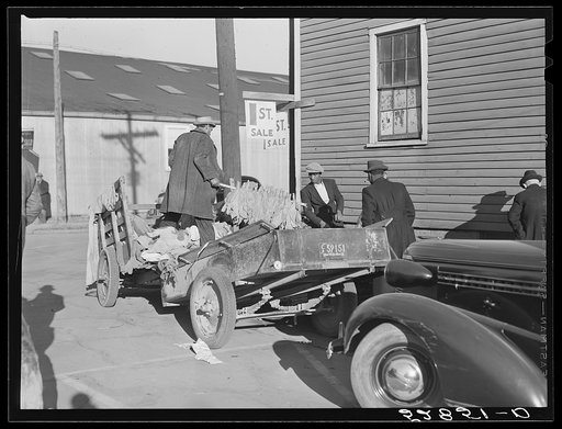 Farmers unloading tobacco from their trailers in front of warehouse on morning of auction sales. Mebane, Orange County, North Carolina