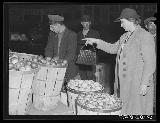 Mrs. Elvin Wilkins (Rosa) buying a basket of apples in Durham, North Carolina. They came here for the day from their farm near Stem, Granville County, to sell their tobacco at auction and do some general shopping