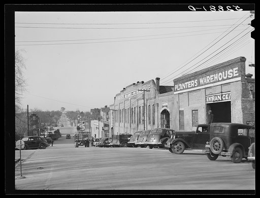 Untitled photo, possibly related to: Tobacco warehouses on main street of South Boston, Halifax County, Virginia. A truck is hauling a load of tobacco after the auction. There are eleven warehouses in this small town