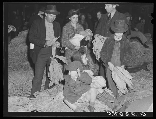 Untitled photo, possibly related to: Farmers and friends waiting around in tobacco warehouse during auction sale. Durham, North Carolina