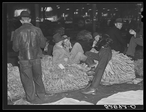 Farmers and friends waiting around in tobacco warehouse during auction sale. Durham, North Carolina