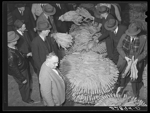 Auctioneer, buyers, and farmers during tobacco auction sale. Warehouse, Durham, North Carolina