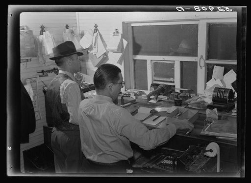 Business managers of plantations paying off cotton pickers on Saturday in plantation store. Mileston, Mississippi Delta