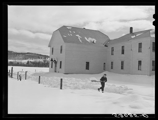 Farmers son shoveling snow out of driveway near Putney, Vermont