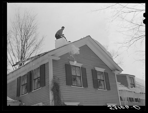 Shoveling heavy snow off roof of house in Woodstock, Vermont