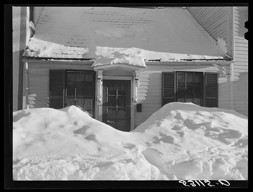 House in Woodstock, Vermont with drifts piled in front of windows and door