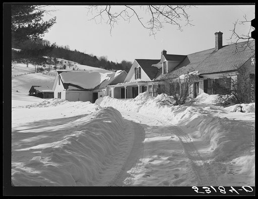 Snow slides off the roof and piles high in front of window of farmhouses. Woodstock, Vermont