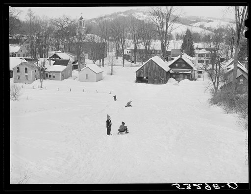 Children sleigh riding down hill in center of town. Woodstock, Vermont