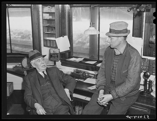 Ticket agent and mail carrier talking in railroad station. Mount Whittier, New Hampshire