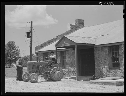 Farmer bringing tractor for repairs at community service center. Faulkner County, Centerville, Arkansas (see general caption)