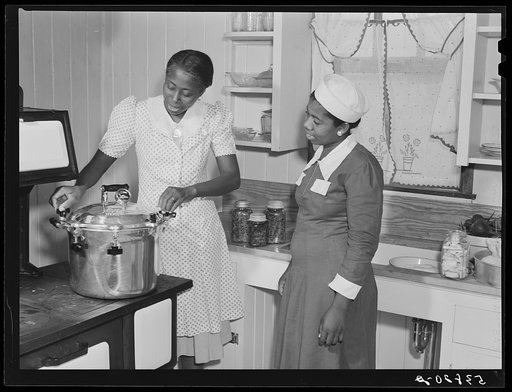 Rachel D. Moore, home management supervisor, demonstrating use of pressure cooker to Almary Kelly. On La Delta Project, Thomastown, Louisiana