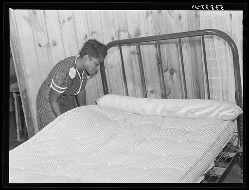 Sidney McLain adjusting the new mattress she made on the bed in her home at La Delta Project. Thomastown, Louisiana