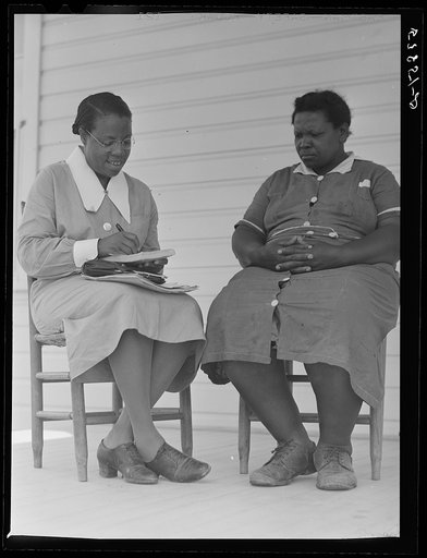 Nurse Marguerite White making plans for next meeting with Rosie Patterson, assistant secretary of Busy Bee home workers club on La Delta Project. Thomastown, Louisiana