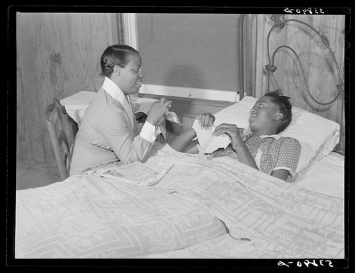 Nurse Marguerite White showing Alice Jane Holden, tuberculosis patient, how to make her own paper cups which can be burned after use in her home on La Delta Project. Thomastown, Louisiana