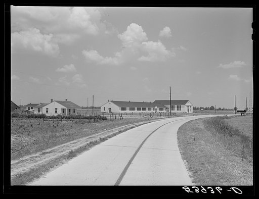 Main highway leading through the project, with school and community building on left. Transylvania Project, Louisiana