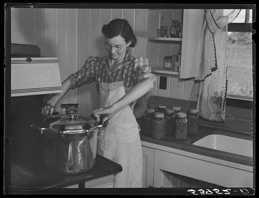 Untitled photo, possibly related to: Mrs. Clarence N. Pace canning English peas in her pressure cooker with Miss Louise Martin, the home management supervisor, helping. Transylvania Project, Louisiana