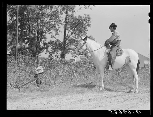 A member of project family stops to talk with his neighbor who has been plowing in cornfield. Transylvania Project, Louisiana