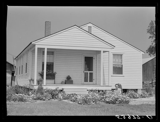 Untitled photo, possibly related to: Mrs. J.G. Stanley cutting flowers in front of her home. Transylvania Project, Louisiana