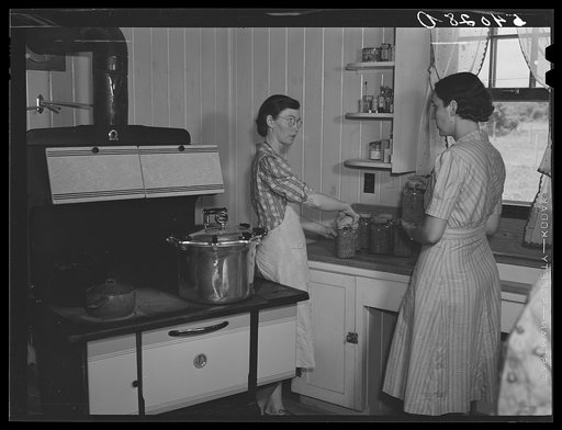 Mrs. Clarence N. Pace canning English peas in her pressure cooker with Miss Louise Martin, the home management supervisor, helping. Transylvania Project, Louisiana
