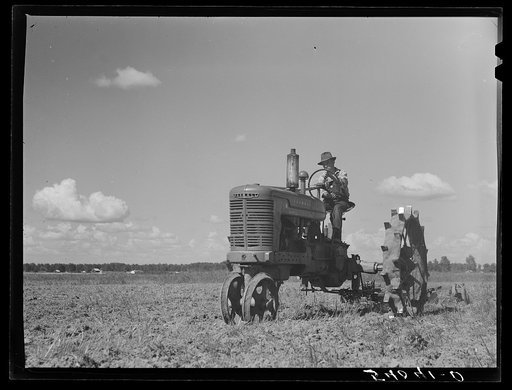 One of the project tractors plowing and discing new land. Transylvania Project, Louisiana