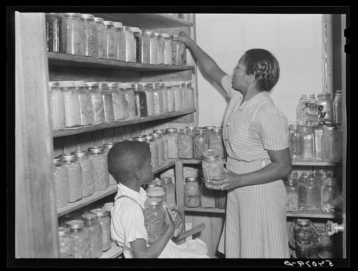 Untitled photo, possibly related to: FSA (Farm Security Administration) borrower's son getting some canned goods for dinner out of the pantry in his home. La Delta Project, Thomastown, Louisiana