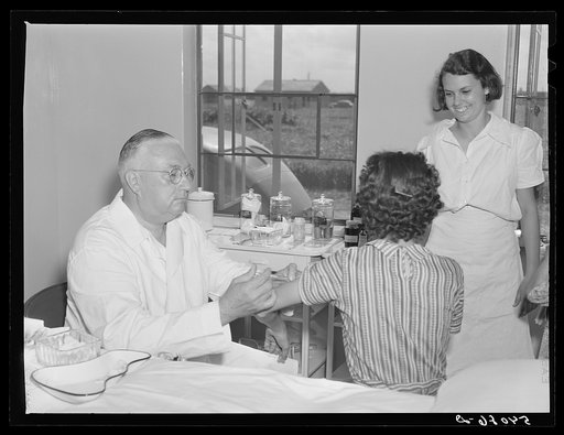 Dr. William J. Buck gives typhoid shot to one of camp members with Marjory Fowler, NYA (National Youth Administration) member assisting the nurse. Osceola migratory labor camp, Belle Glade, Florida