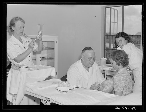 Dr. William J. Buck giving typhoid innoculation to child and mother, with Nurse Smock, and Marjory Fowler, NYA (National Youth Administration) camp member, assisting him. Osceola migratory labor camp. Belle Glade, Florida