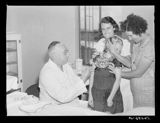 Untitled photo, possibly related to: Dr. William J. Buck giving typhoid innoculation to child and mother, with Nurse Smock, and Marjory Fowler, NYA (National Youth Administration) camp member, assisting him. Osceola migratory labor camp. Belle Glade, Florida