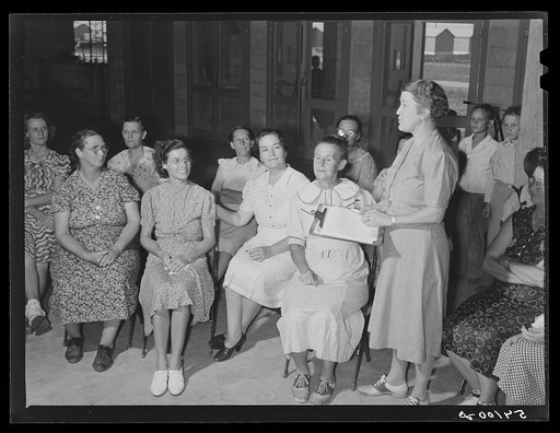 Home management supervisor Mrs. Merrin has a woman's club group discussion and meeting in the assembly building at Osceola migratory labor camp. Belle Glade, Florida