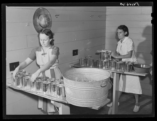 Camp members canning tomatoes in the utility building at Osceola migratory labor camp. Belle Glade, Florida