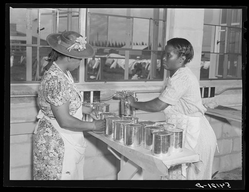 Home management supervisor Corinne Williams helping camp members can tomatoes in utility building. Okeechobee migratory labor camp. Belle Glade, Florida