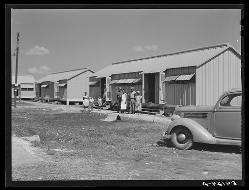 Camp members outside their shelter unit at Okeechobee migratory labor camp. Belle Glade, Florida