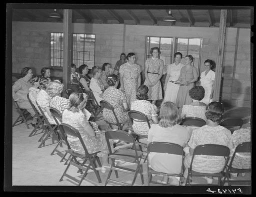 Home management supervisor Mrs. Merrin has a women's club group discussion and meeting in the assembly building at Osceola migratory labor camp. Belle Glade, Florida