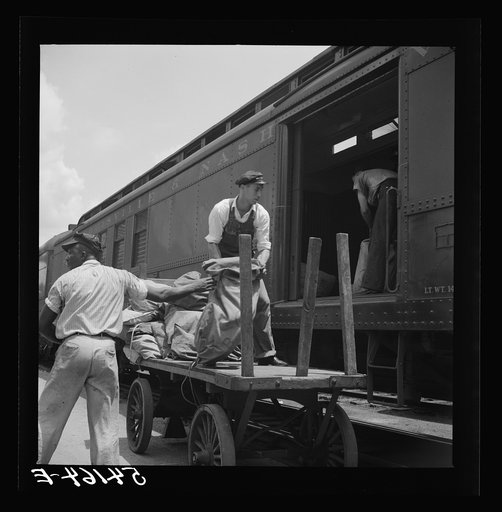 Loading mail into mail car. L&N railroad station, North Florida