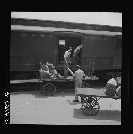 Loading mail into mail car. L&N railroad station, North Florida