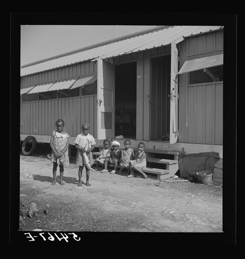 Untitled photo, possibly related to: Children of camp members playing outside their shelters in Okeechobee migratory labor camp. Belle Glade, Florida