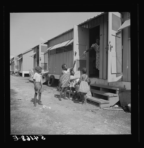 Untitled photo, possibly related to: Children of camp members playing outside their shelters in Okeechobee migratory labor camp. Belle Glade, Florida