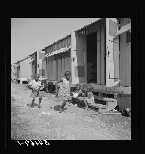 Children of camp members playing outside their shelters in Okeechobee migratory labor camp. Belle Glade, Florida