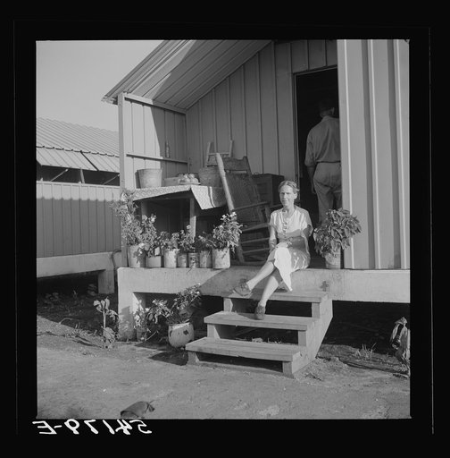 Untitled photo, possibly related to: Camp member on porch of her shelter at Osceola migratory labor camp. Belle Glade, Florida